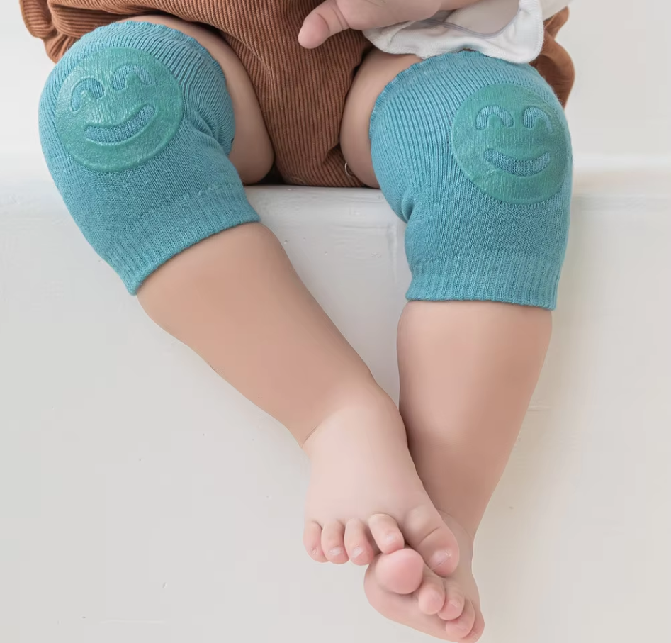 Kids knee sleeve worn on both knees of a baby sitting on a flat surface with padded knee areas visible.