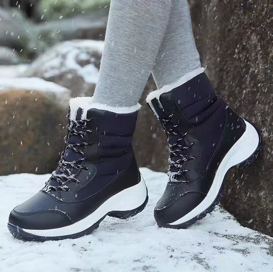 A pair of black WeRelieve winter boots with lace-up closure, lining, and non-slip sole, worn in the snow.